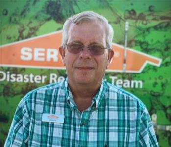 White male.  Wearing glasses and a green and white plaid shirt. 